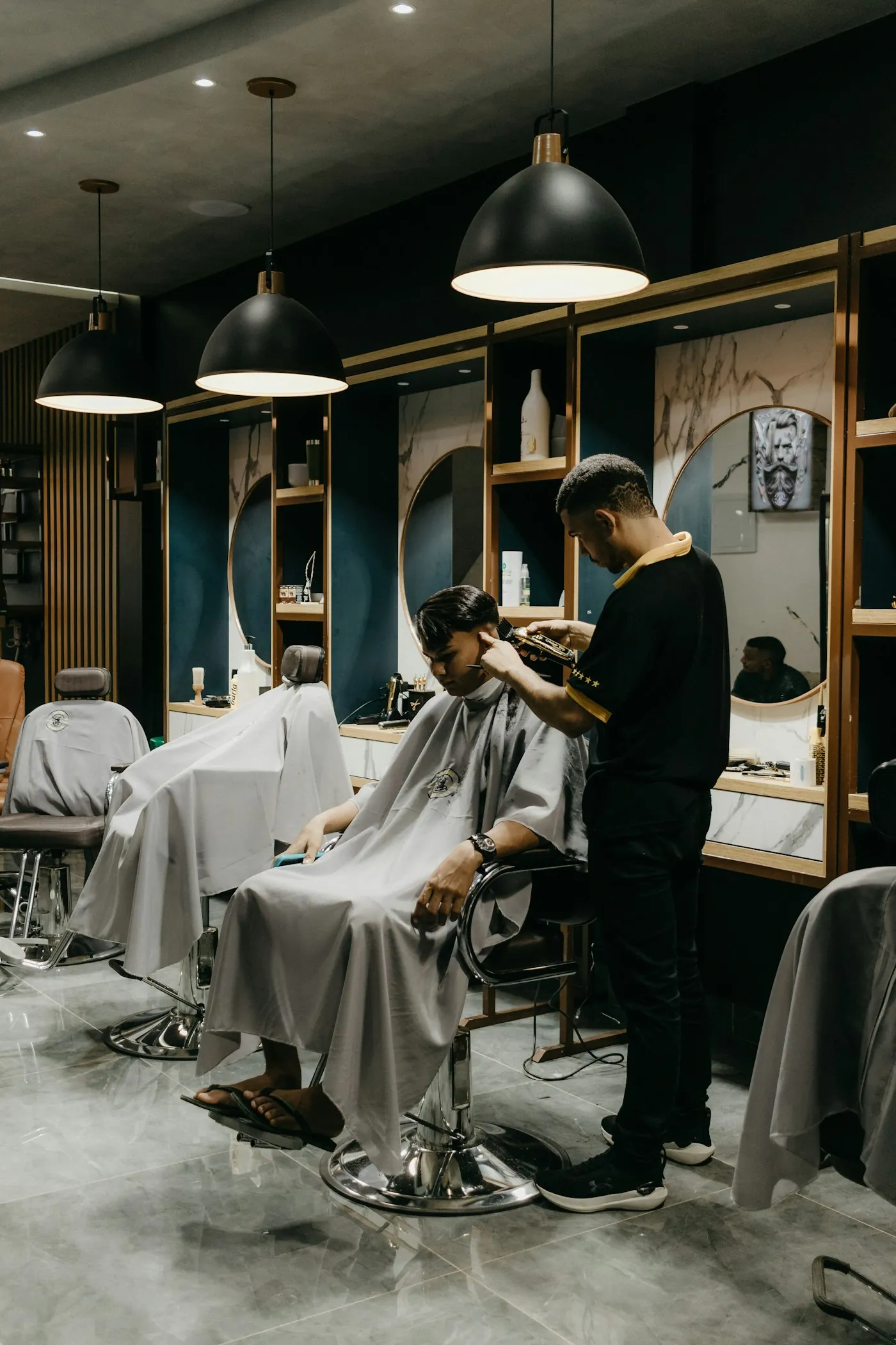 Không gian tiệm barber với ghế cắt tóc và thợ đang làm việc